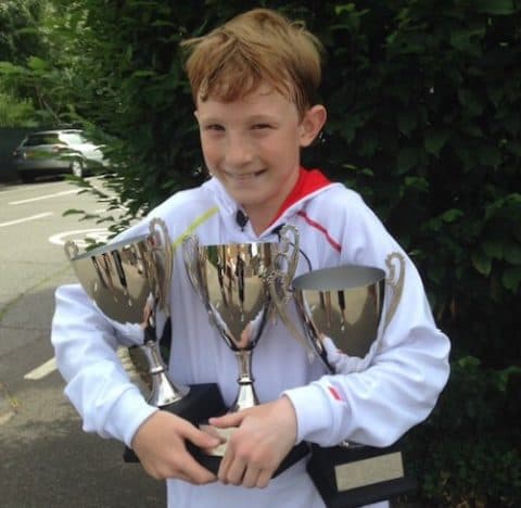 Young athlete celebrating with trophies